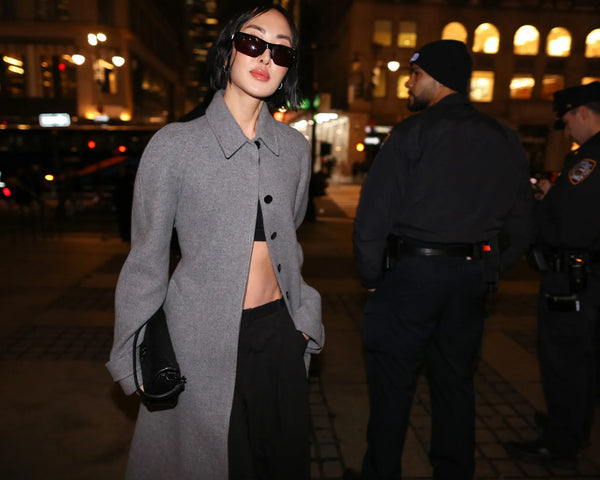 woman with grey coat and black crop top and pants