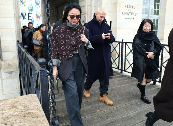 woman with grey suit and a brown scarf tied around her upper body