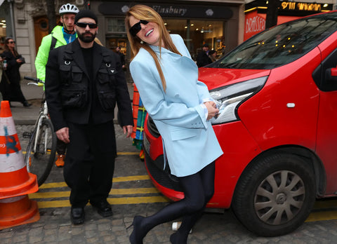Fashion journalist Anna Dello Russo with a baby blue jacket and black leggings