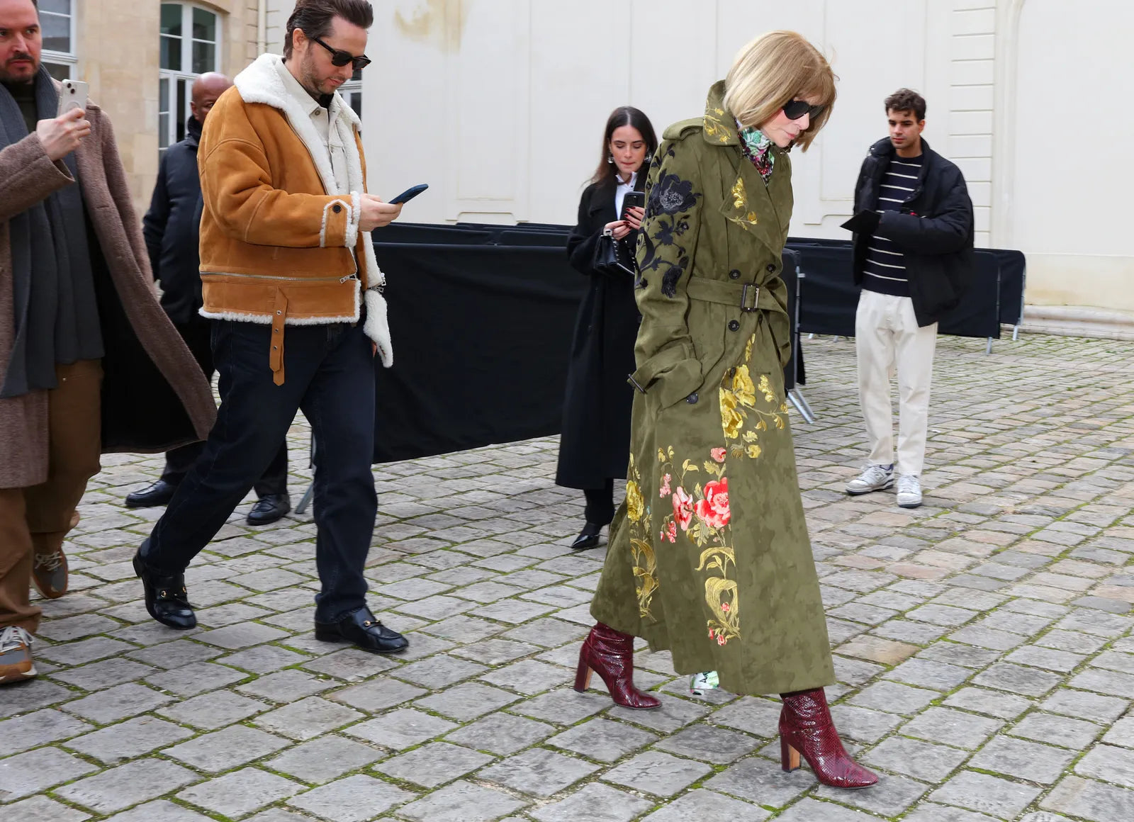 Anna Wintour with a green coat with embroidery and burgundy boots