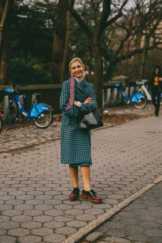 woman with checkered petrol coat and heeled brogues