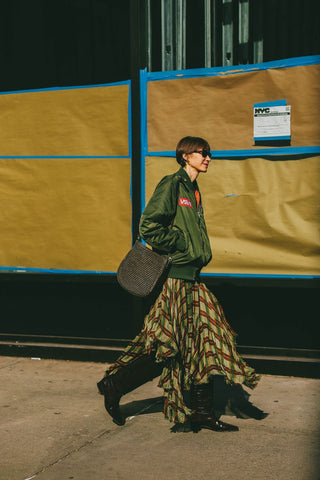 woman with green bomber jacket and checkered skirt