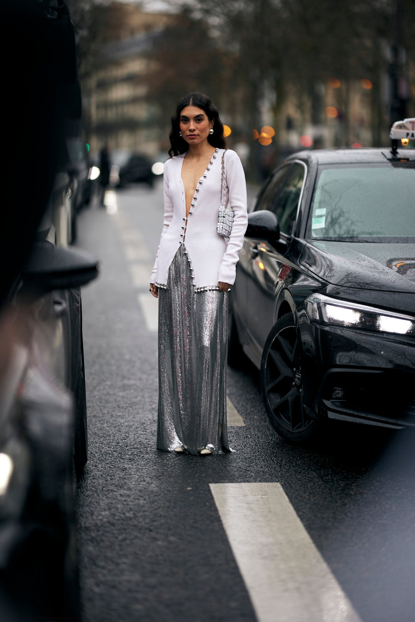 woman with white cardigan and silver maxi skirt