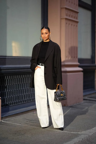 woman with black blazer and white wide leg jeans