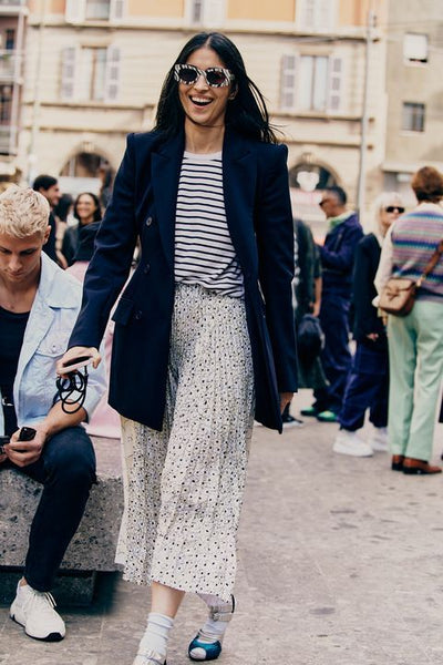 woman wearing oversized blazer with striped top and polka dots skirt