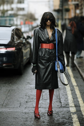 woman with black patent leather overcoat and red details