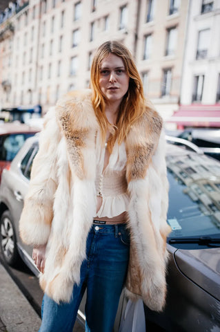 woman with faux fur ivory coat, white blouse and jeans
