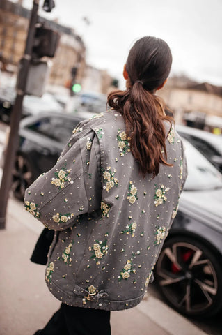 woman with grey jacket with embellished flowers