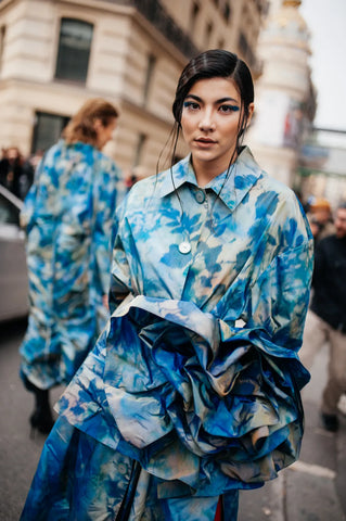 woman with blue floral jacket with a giant flower detail in front