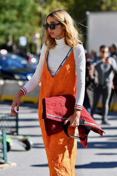 woman wearing an orange slip dress with a turtleneck white top