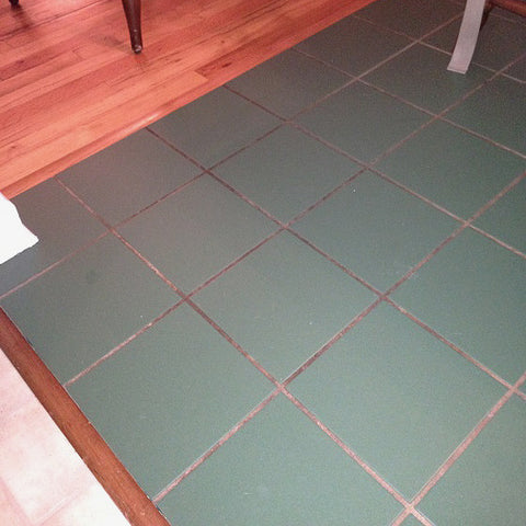 a green floor with dirty grout