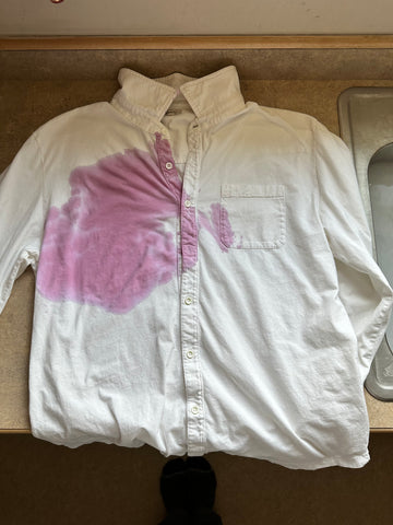 a white dress shirt with a red wine stain on it.