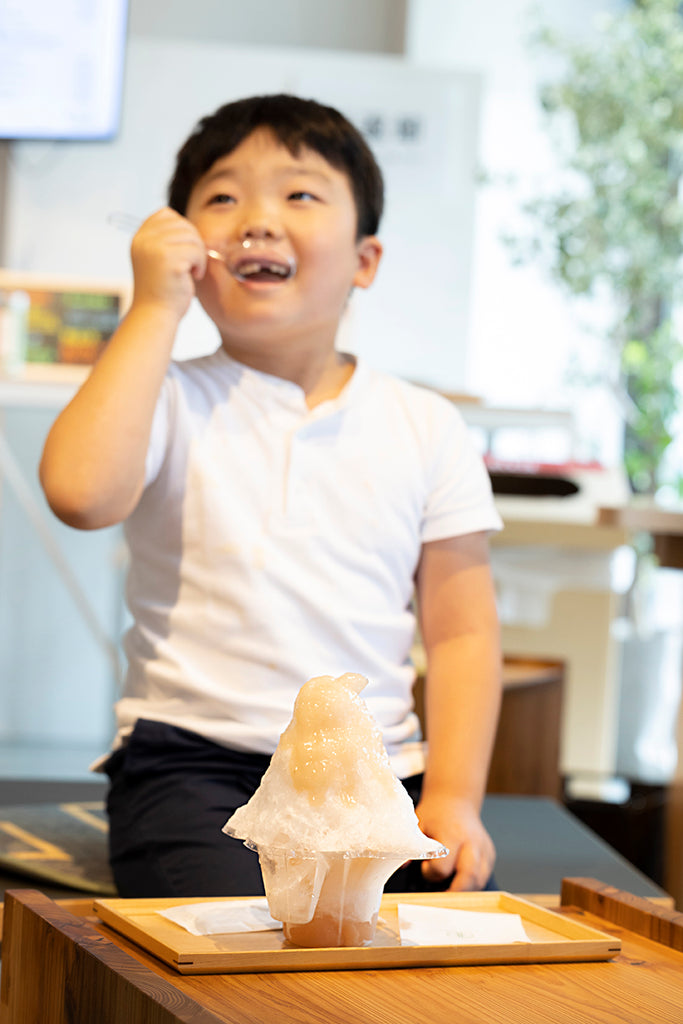 山梨県産桃のかき氷を食べる男の子