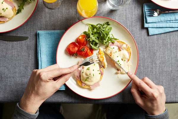 close up of man cutting into a bite of healthy breakfast 