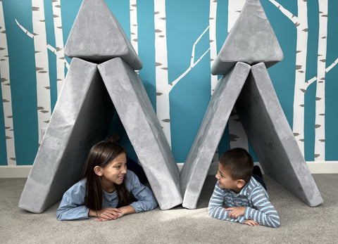 A boy and a girl having fun, hiding under tents created with Mod Blox microsuede play furniture.