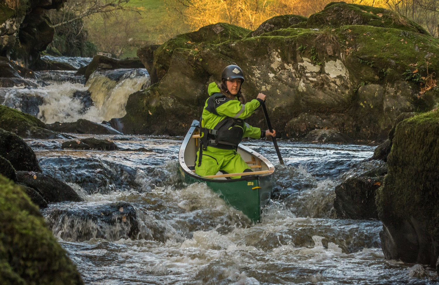 A canoeist running white water wearing a buoyancy aid