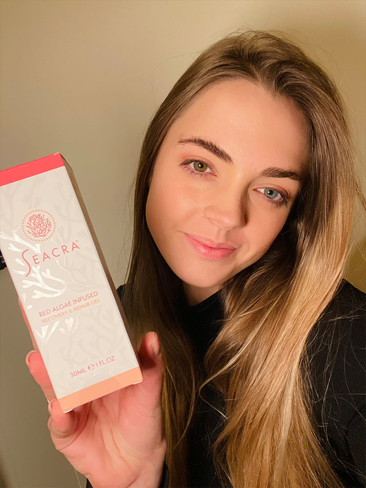 Person holding a Seacra skincare product box.
