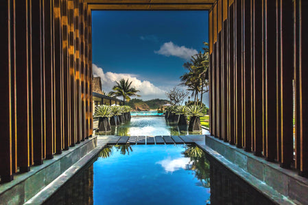 Designer-Hotel Pool mit Palmen und Meer im Hintergrund