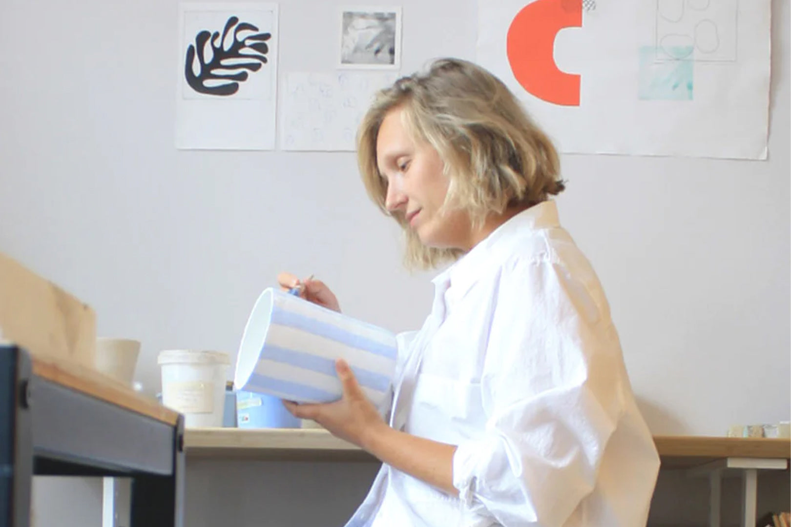 A creative female artist: Andrea Frieling, working on her ceramic in a sunlit studio.
