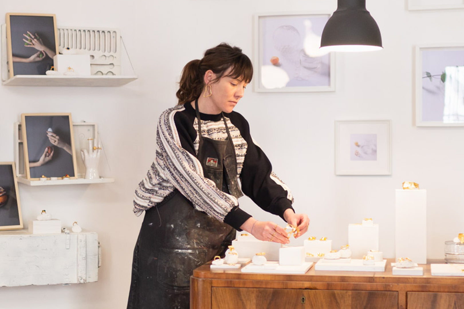 Artisan arranging her handmade jewelry in a boutique display, blending artistry with motherhood.