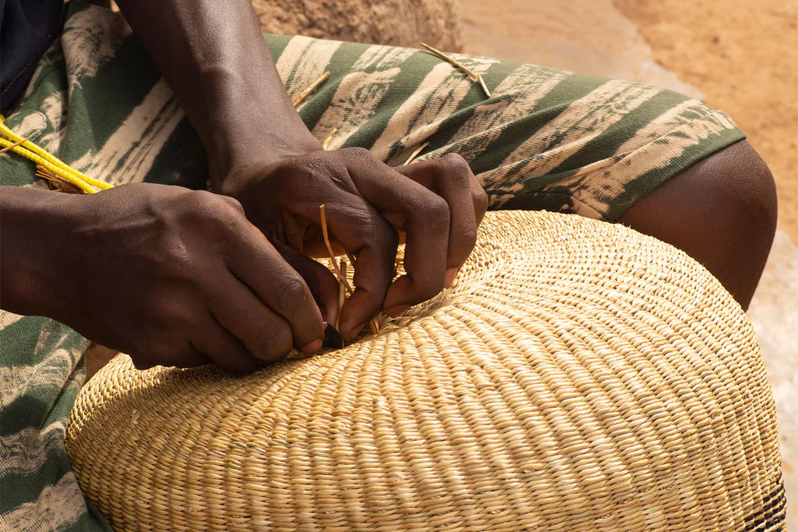 A skilled artisan handcrafts a woven picnic basket, showcasing the traditional technique and natural materials that contribute to an eco-friendly lifestyle.