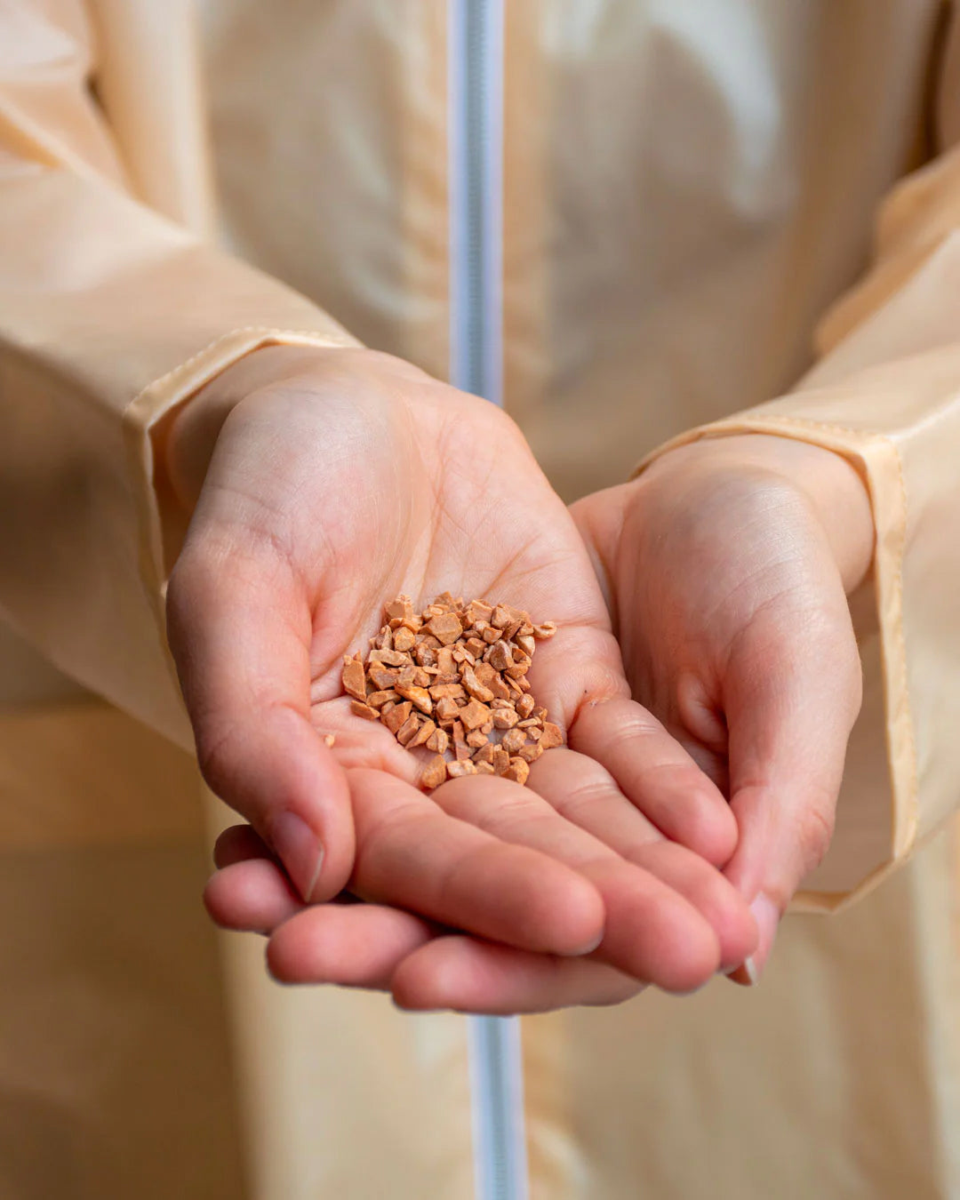 A person holding a handful of natural cork granules, highlighting eco-friendly materials used in products.