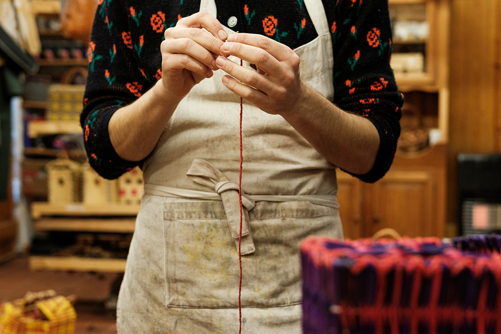 meticulously working on a knitting project with yarn, exemplifying the hands-on approach to sustainable fashion creation.