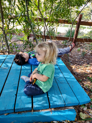 Kids snacking and relaxing in a willow hut on the children's garden at the SLO Botanical Garden