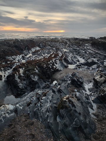 The sun sets early over tide pools in Pismo Beach during the king tides negative low tide