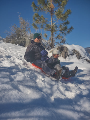 Two kids sled with their dad in Frazier Park Ventura and Kern counties
