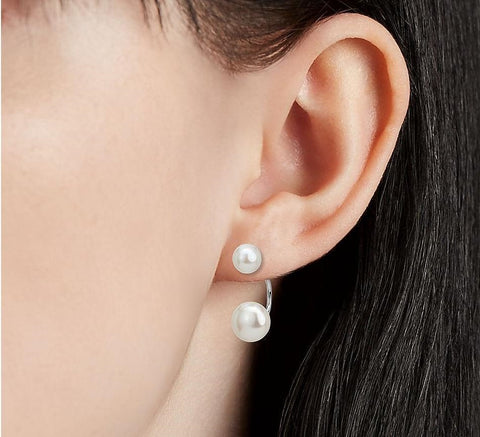 Women wear front-back pearl earrings.