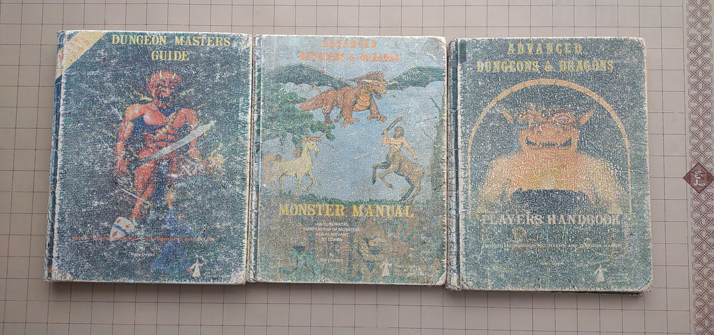 Advanced Dungeons and Dragons 1st Edition Core Rulebooks. The Player's Handbook (Idol Cover), the Monster Manual (menagerie of monsters cover) and the Dungeon Master's Guide (Efreet Cover).