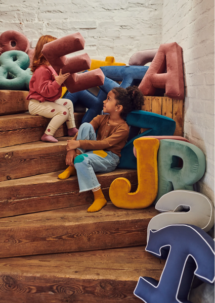 Girls sitting on stairs with velvet letter cushions. First day at school gift idea for kids by Bettys Home