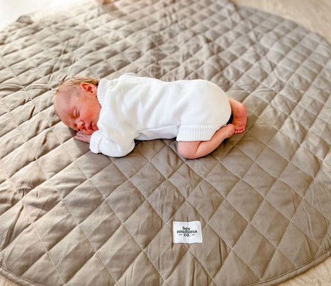 Image of baby asleep on a playmat