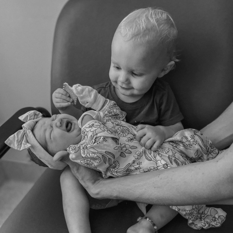 Image of brother meeting baby sister for the first time