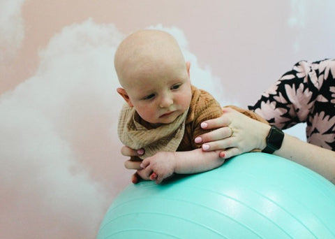 Baby doing tummy time on an exercise ball