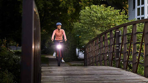 ライトのついたクロスバイクで楽しそうに走る女性