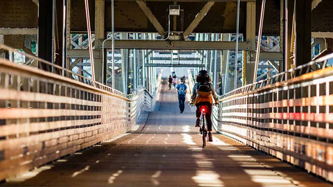 リアライトを点灯させながら、市街地の自転車道路を走る通勤ライダー