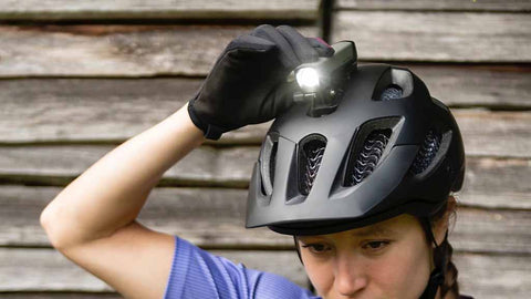 ヘルメットの上につけたライトのスイッチを押している女性