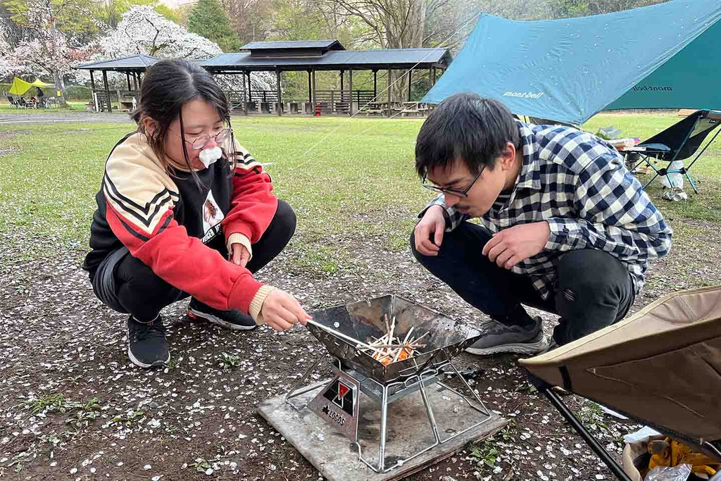 相田指導のもと火起こし体験をする高橋