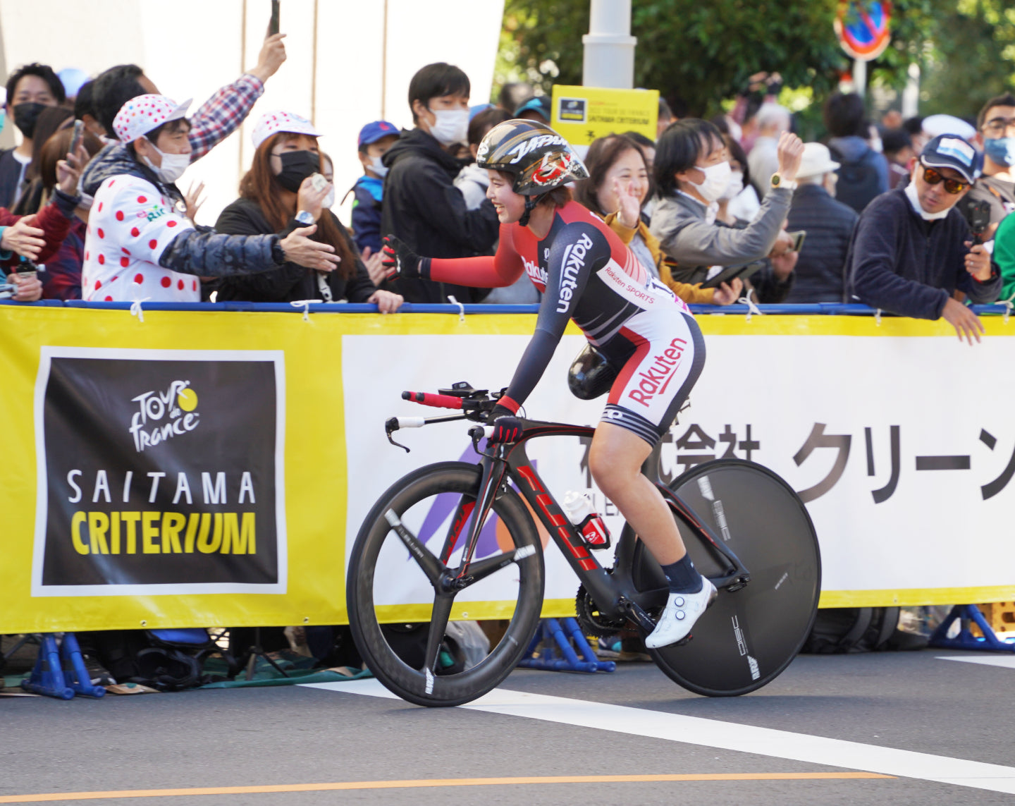 観客の声援に応えるパラサイクリングの選手