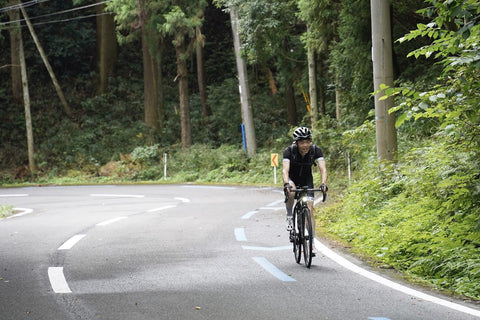 山を自転車で登る様子を正面から撮影