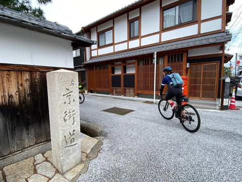 八幡堀の京街道の標石と自転車に乗る人を背後から撮影