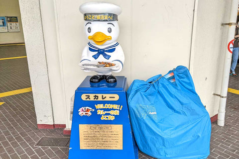 横須賀のマスコットスカレーと水色の輪行袋