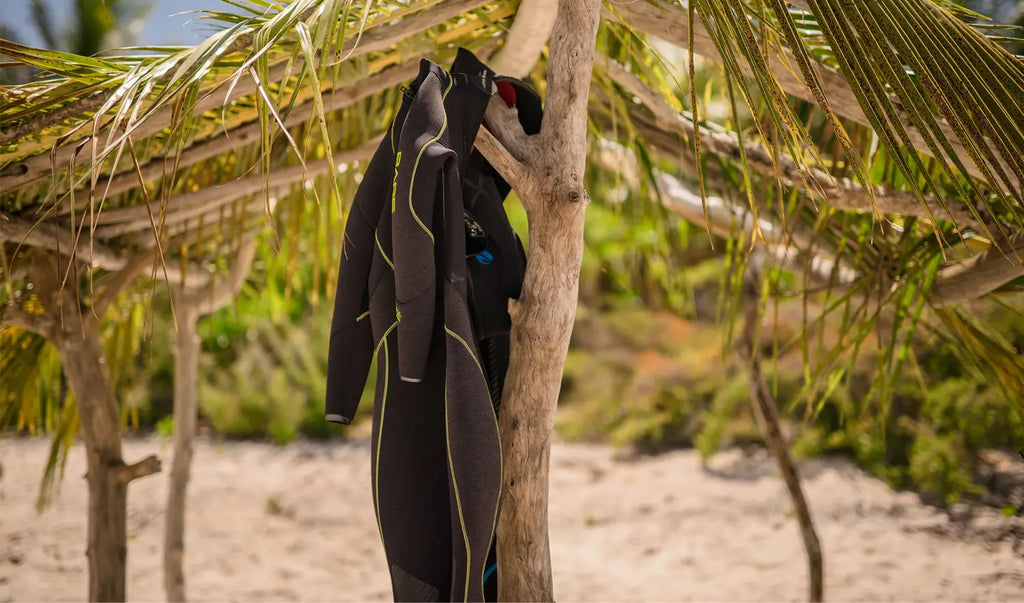 Trajes de neopreno colgados para secar en la playa