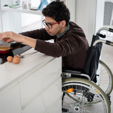 person in a wheelchair making breakfast