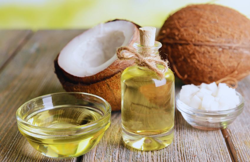 coconut oil on wooden desk with whole coconut in the background