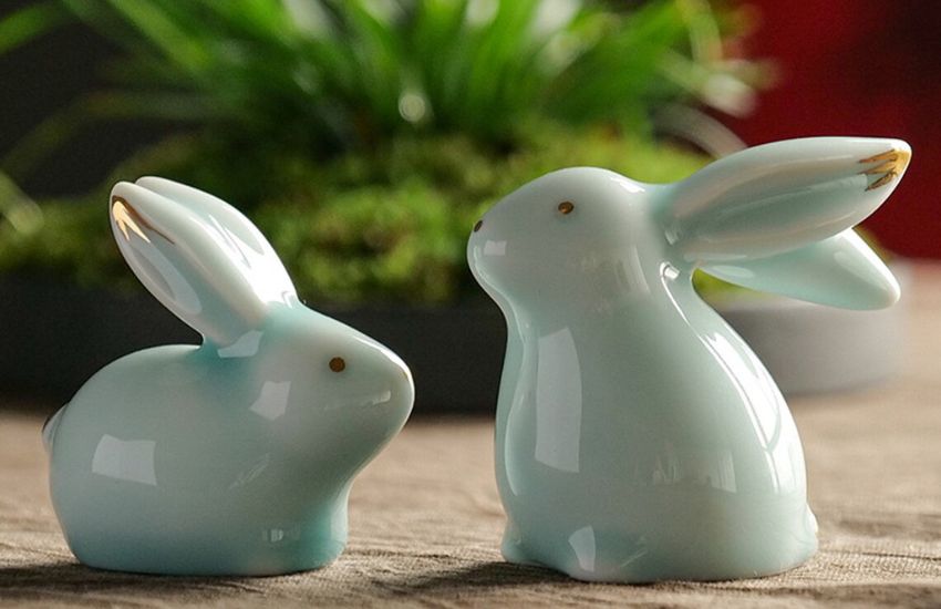 Two green ceramic rabbit decor on table