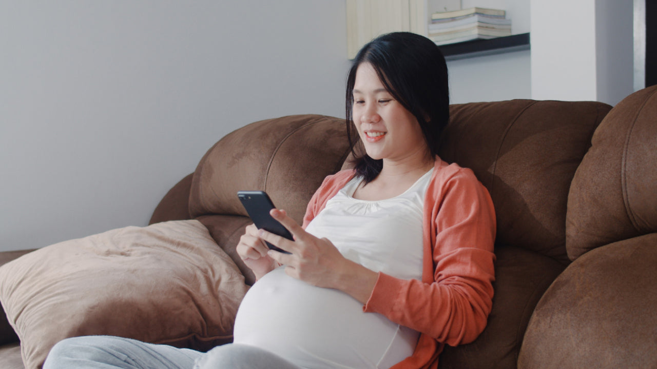 Pregnant women searching nursing bra with mobile phone