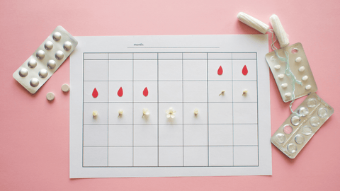 paper calendar print out dotted with pills and tampons.